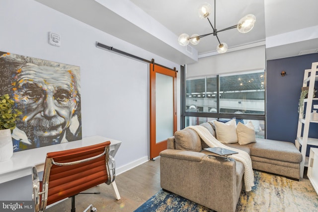 living area featuring wood finished floors, baseboards, an inviting chandelier, and a barn door