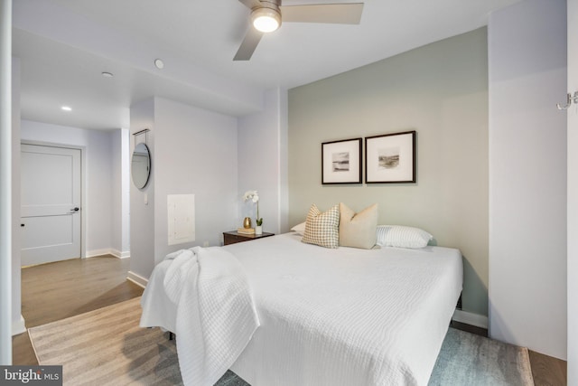 bedroom with ceiling fan, light wood-style flooring, and baseboards