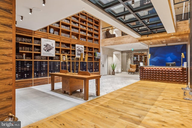 wine area with a high ceiling, mail area, and wood finished floors