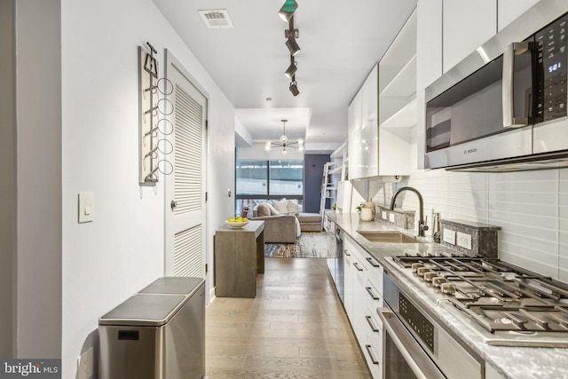 kitchen featuring a sink, white cabinets, appliances with stainless steel finishes, backsplash, and modern cabinets