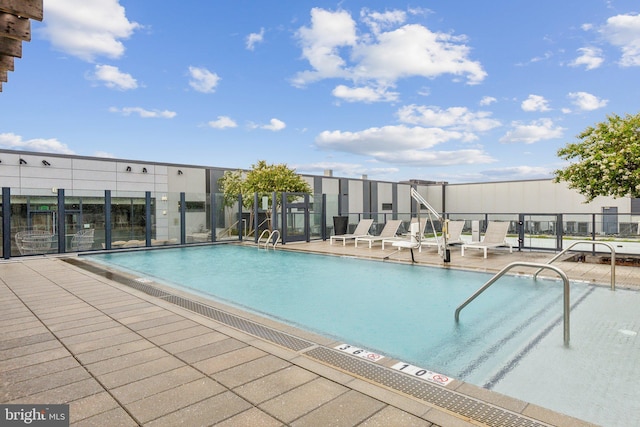 community pool with fence and a patio