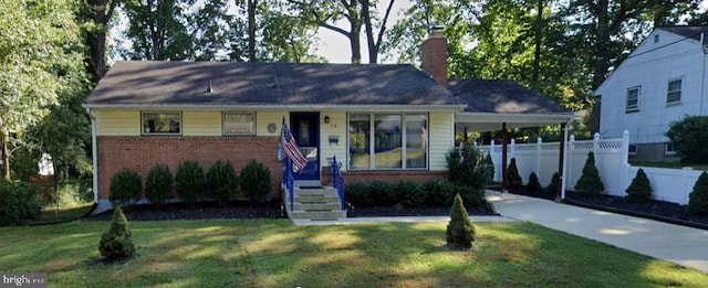 ranch-style house featuring brick siding, concrete driveway, fence, a carport, and a front yard