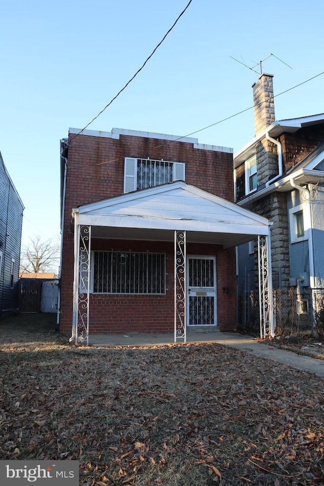 rear view of house with fence and brick siding