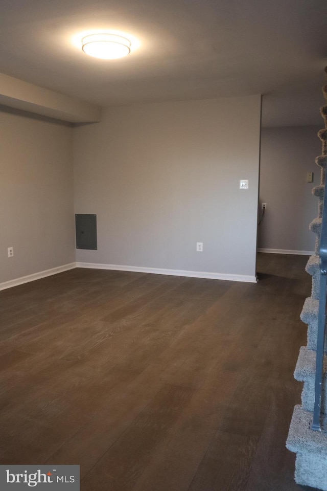 empty room featuring dark wood-type flooring and baseboards