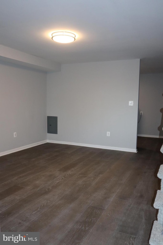 spare room featuring dark wood-style floors and baseboards