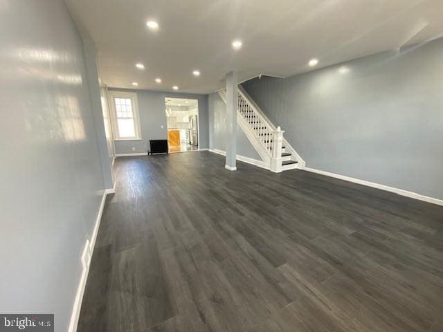 unfurnished living room featuring dark wood-style floors, recessed lighting, stairway, and baseboards