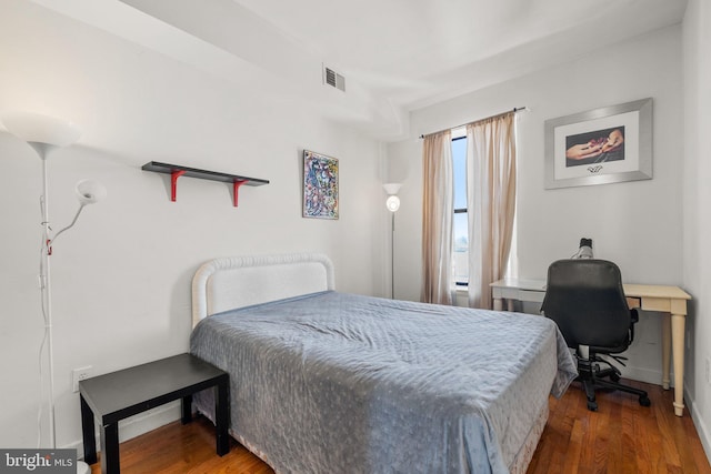 bedroom featuring visible vents and wood finished floors