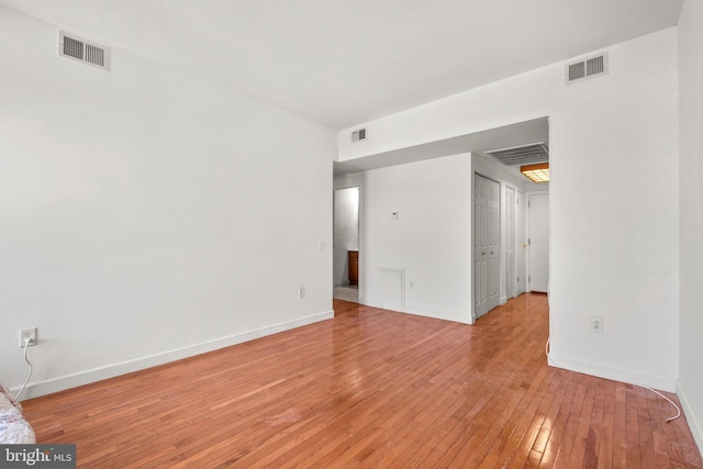 interior space with light wood-type flooring, baseboards, and visible vents