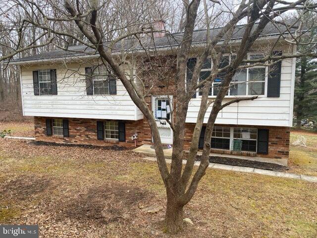 view of front of house featuring brick siding and a front lawn