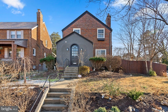 view of front of property featuring brick siding and fence