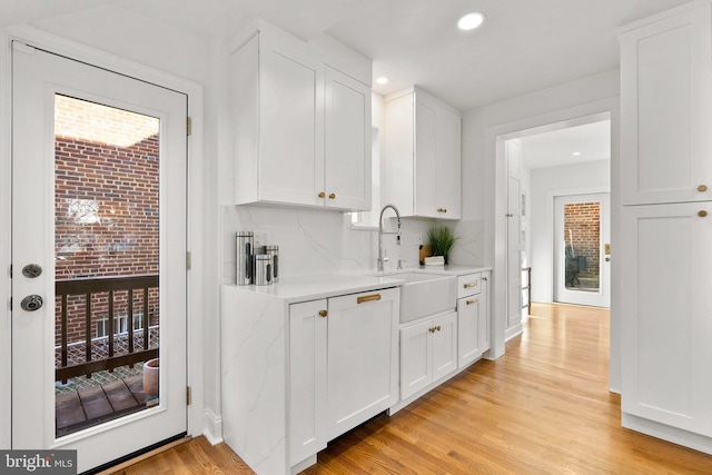 bar with recessed lighting, a sink, light wood-style flooring, and decorative backsplash