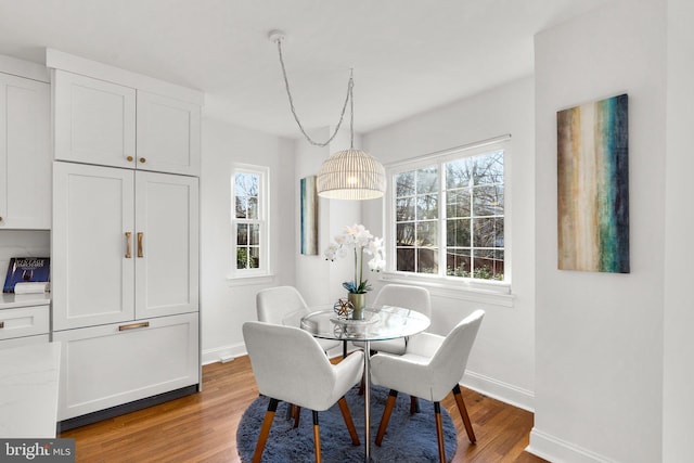 dining area with baseboards and wood finished floors