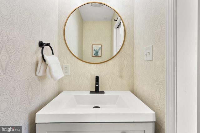 bathroom featuring vanity and wallpapered walls