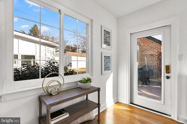 doorway featuring baseboards and wood finished floors