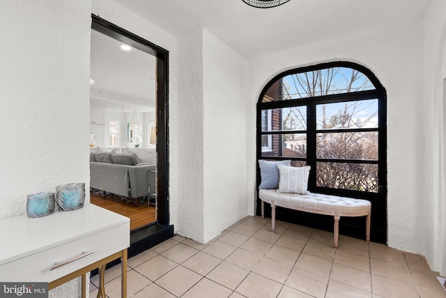 living area with a textured wall and light tile patterned floors