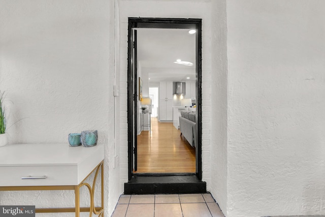 interior space with a textured wall and light tile patterned floors