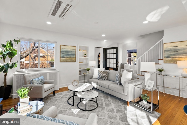 living area with stairway, visible vents, wood finished floors, and recessed lighting