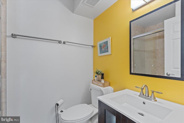 full bathroom featuring toilet, vanity, an enclosed shower, and visible vents