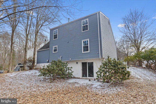 view of snow covered back of property