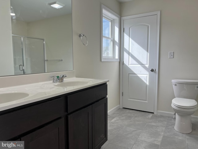 full bathroom featuring baseboards, double vanity, a sink, and a shower stall