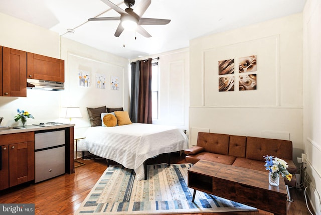 bedroom with dark wood-style floors, ceiling fan, and a sink