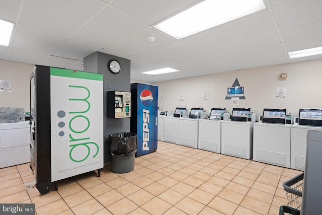 shared laundry area featuring washer and clothes dryer and light tile patterned flooring