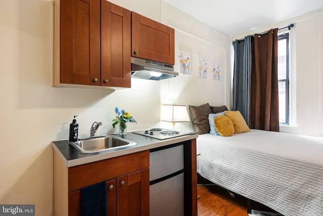 bedroom featuring multiple windows, a sink, and dark wood finished floors