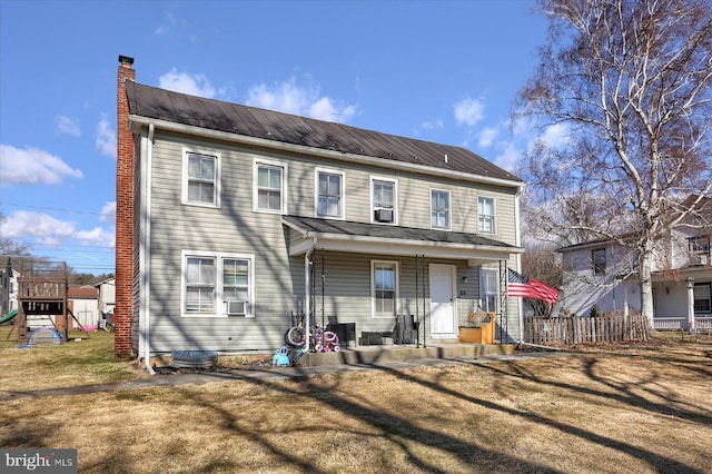 back of property featuring cooling unit, a yard, a chimney, a playground, and metal roof