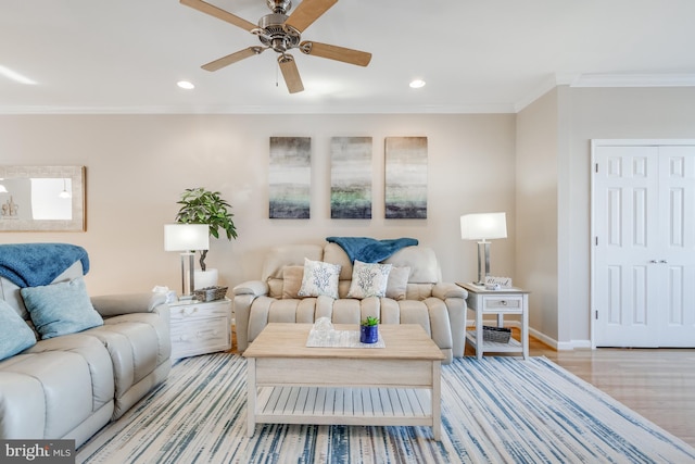 living area featuring recessed lighting, ornamental molding, a ceiling fan, wood finished floors, and baseboards