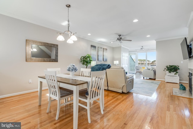 dining space featuring light wood-style flooring, baseboards, and crown molding