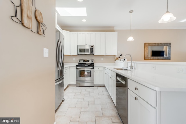 kitchen featuring stainless steel appliances, a skylight, a sink, light countertops, and crown molding