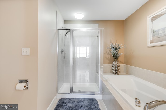 bathroom featuring a garden tub, a shower stall, and tile patterned floors