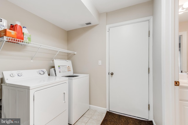 laundry area featuring laundry area, light tile patterned flooring, visible vents, and washer and dryer