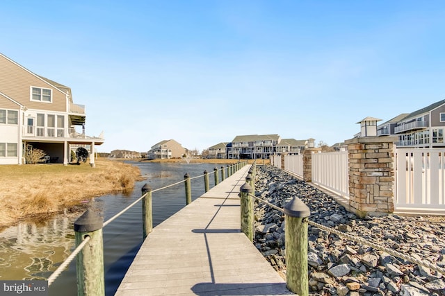 view of dock with a residential view and a water view