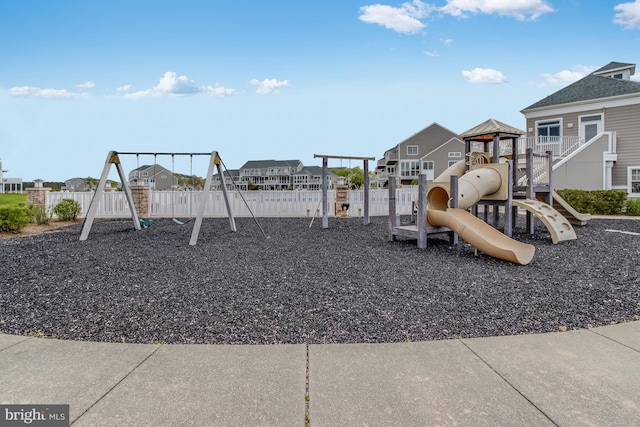 community play area featuring a residential view and fence