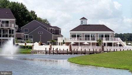 back of house with a yard, a water view, and fence