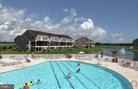 community pool with a patio area and fence