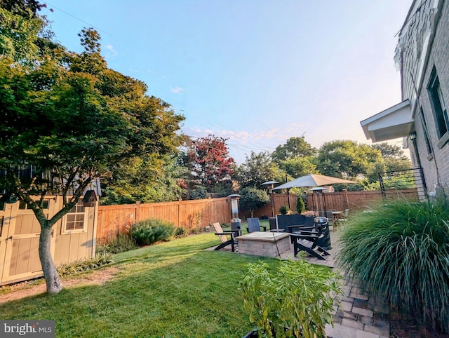 view of yard featuring a fire pit and a fenced backyard