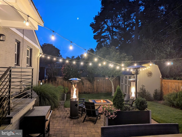 patio at night with an outdoor fire pit and fence