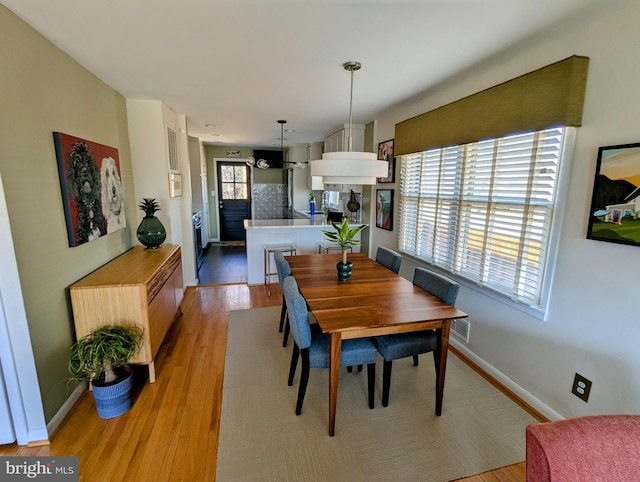 dining area featuring baseboards and light wood-style floors