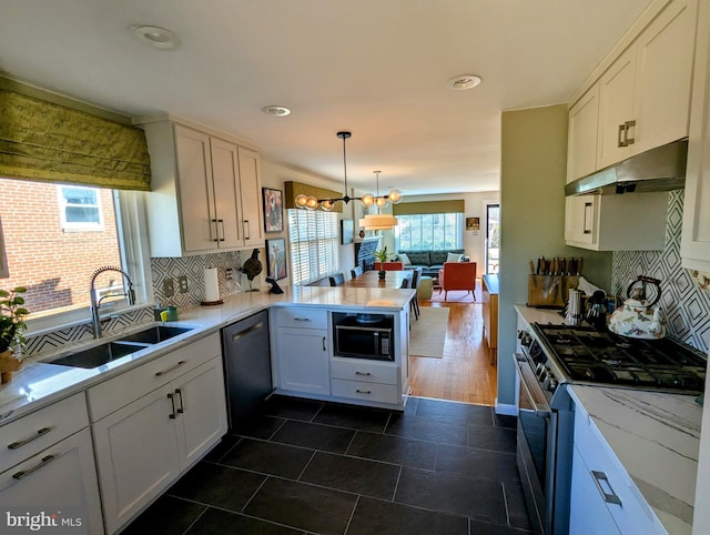 kitchen featuring dishwashing machine, under cabinet range hood, a peninsula, a sink, and stainless steel range with gas stovetop