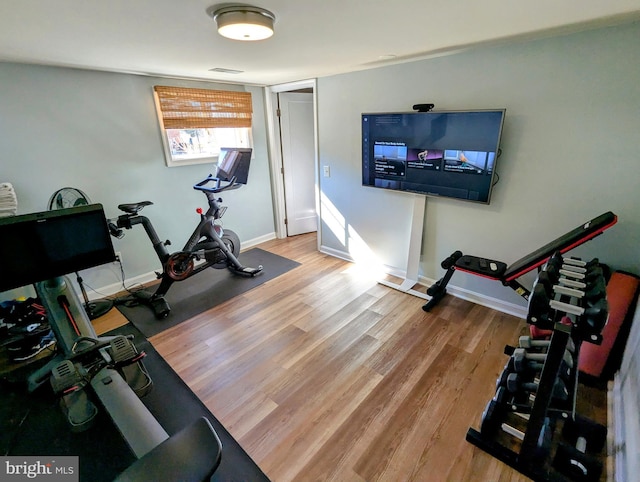 workout room with visible vents, baseboards, and wood finished floors