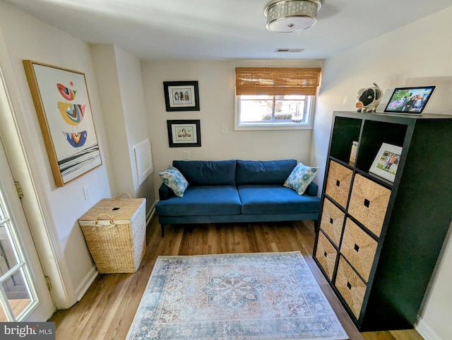 sitting room featuring light wood-type flooring, baseboards, and visible vents