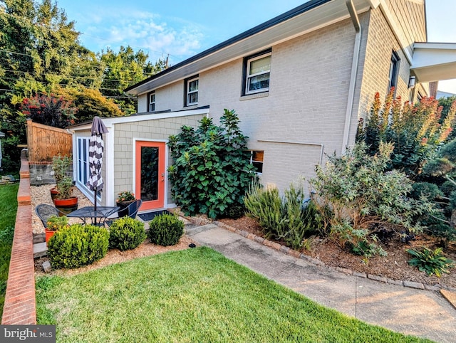 view of front facade with brick siding and a front yard