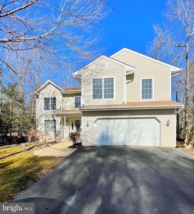 traditional home with an attached garage and aphalt driveway