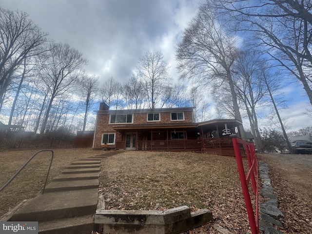 view of front of home featuring brick siding, a chimney, and a porch