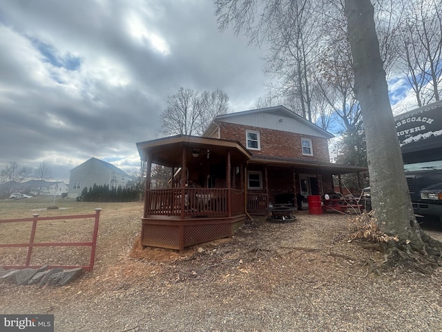 back of property featuring covered porch and brick siding