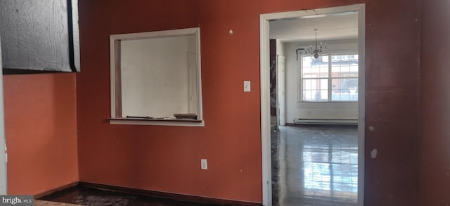 spare room featuring baseboards, a baseboard heating unit, and a notable chandelier