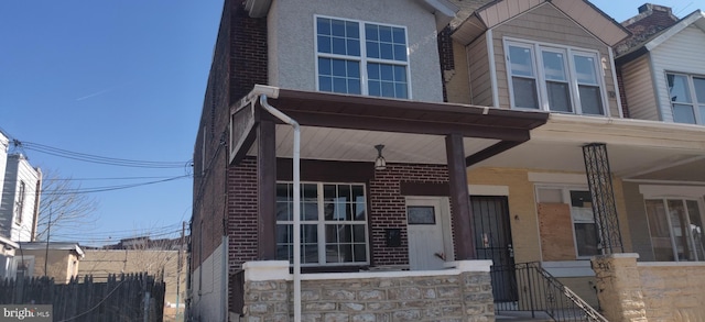 view of front facade with brick siding and fence