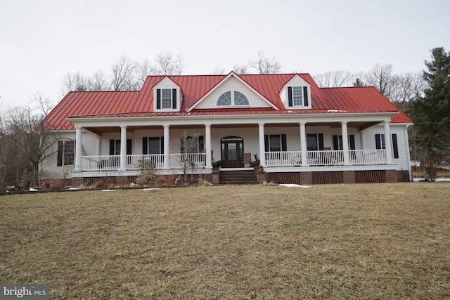 country-style home featuring covered porch, a standing seam roof, metal roof, and a front yard